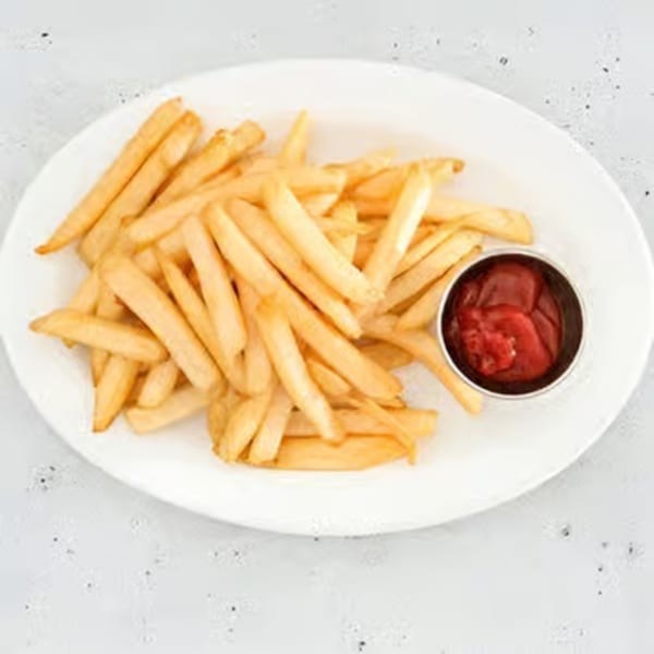 Golden french fries on a white plate with a side of ketchup.